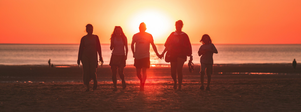 Silhouette of a family at the beach during sunset.